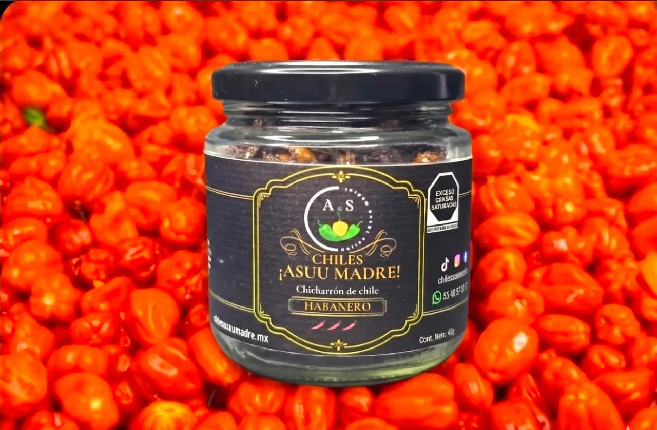 Vibrant orange habanero peppers in a dark wooden bowl with sharp shadows and intense lighting, cinematic food photography