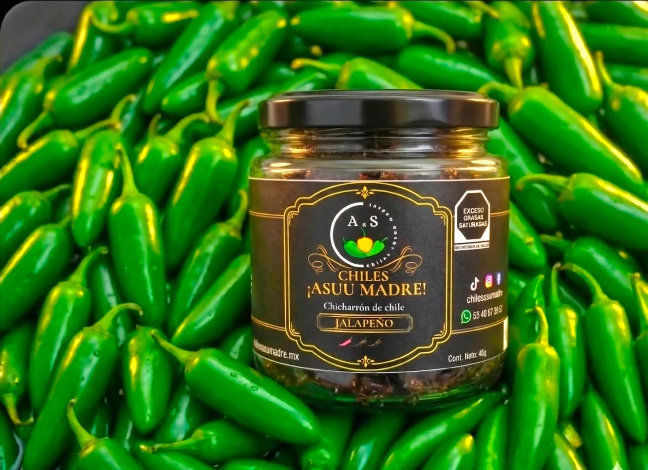 Close-up of fresh green jalapeño peppers with water droplets on a dark textured slate background, professional culinary photography