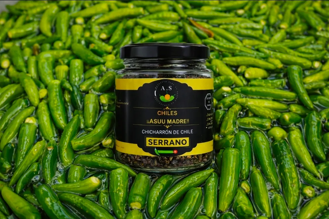 Gourmet artisanal chili crunch jar with oil and seeds visible, dramatic lighting highlighting the texture and golden oil